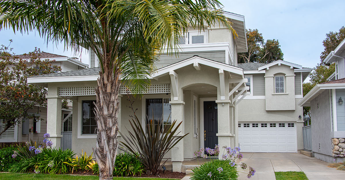 Two-story Carlsbad home with palm tree and landscaped front yard